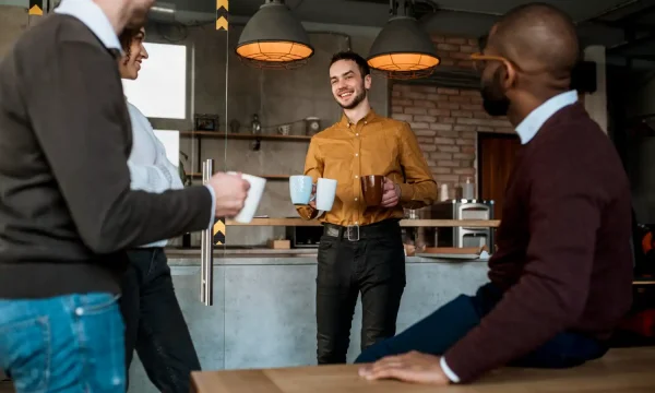 smiley-man-carrying-mugs-with-coffee-his-colleagues